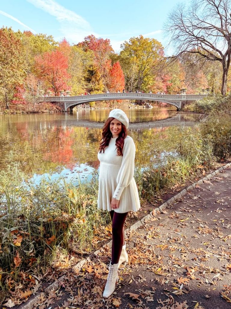 Standing with the Bow Bridge and colourful fall leaves in the background, a famous New York photo spot.