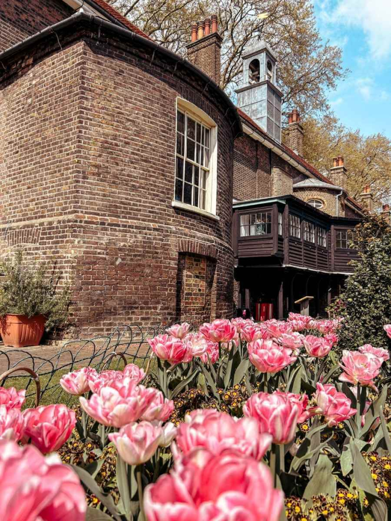 Flowers in bloom in the garden with the Museum of the Home building in the background

