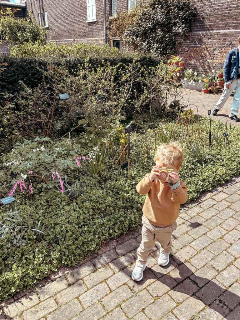Toddler enjoying a toy camera from the sensory backpack at the Museum of the Home
