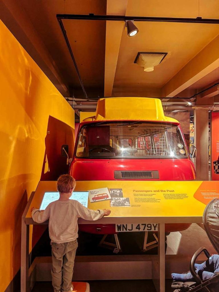 Young child looking at a historic mail van display at The Postal Museum, London.