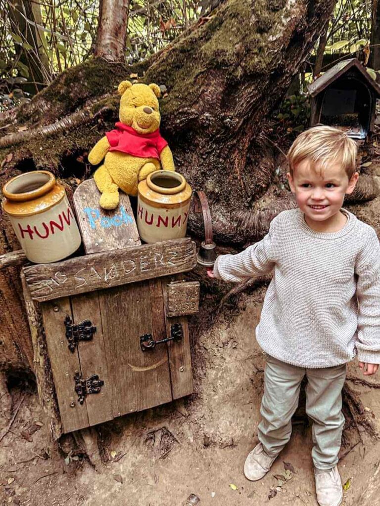Young boy standing outside Winnie the Pooh’s house on the Ashdown Forest trail