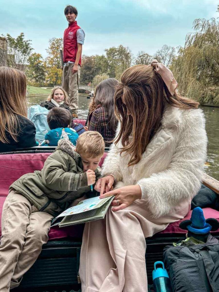 Mum in the City helping her son work on a fun Cambridge punting tour activity book.