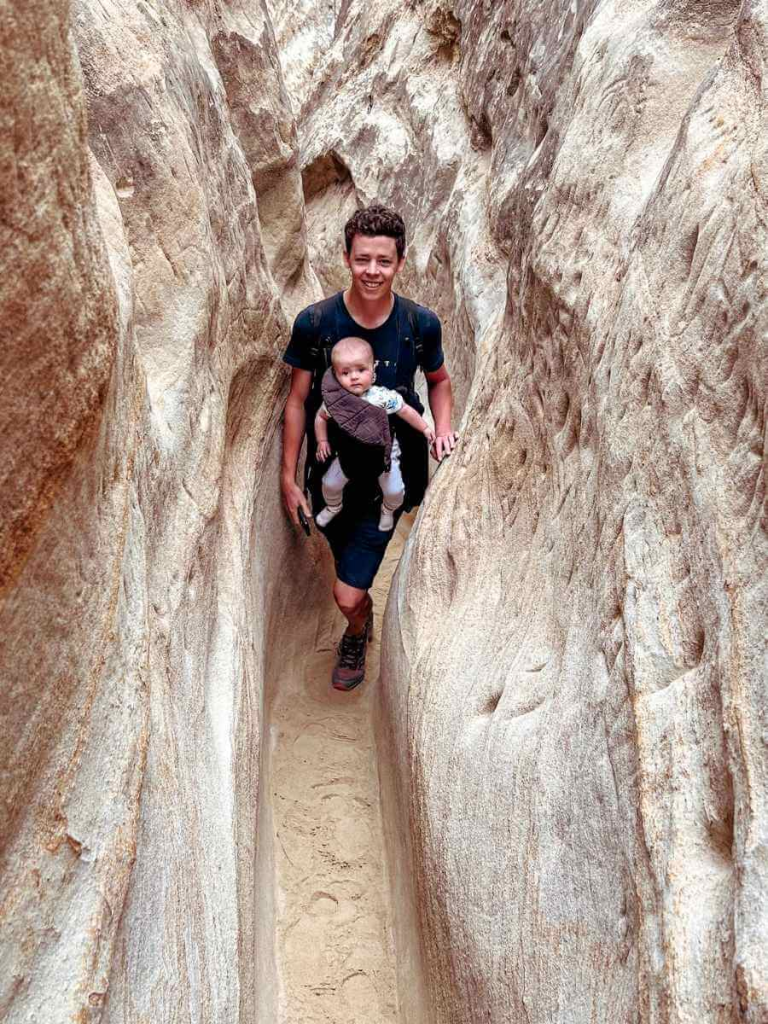 Hiking Annie’s Canyon Trail in San Diego with a baby in carrier on the narrow sandstone path