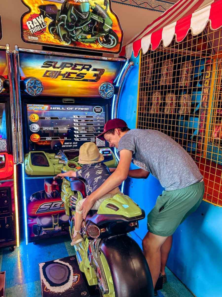 Toddler enjoying the arcade games on Santa Monica Pier – a fun stop on a Los Angeles family vacation.