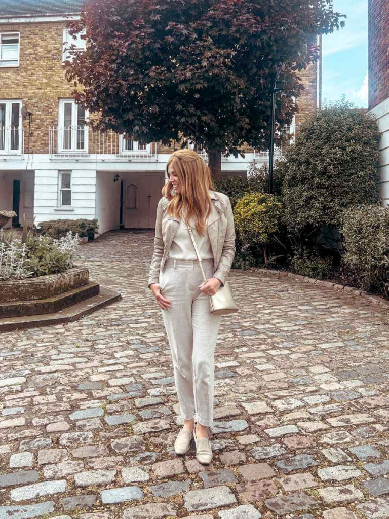 Layered casual look with cigarette trousers, a leather jacket, blouse, and mules – perfect for spring days