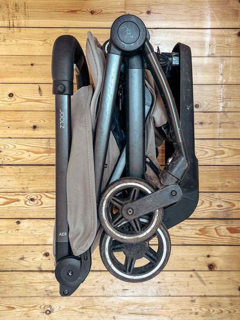 Joolz Aer+ stroller folded with the ride-on footboard still attached.