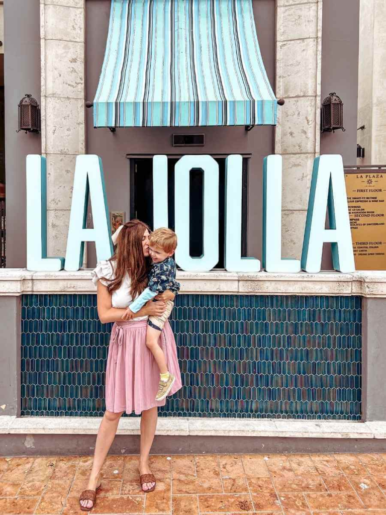 Mum in the City and her son by the La Jolla sign, a must-visit location during a family trip to San Diego
