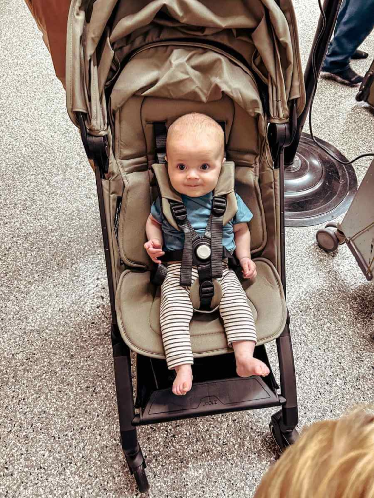 Baby using the Joolz Aer+ stroller for the first time at 4 months old, sitting comfortably with the harness fastened.