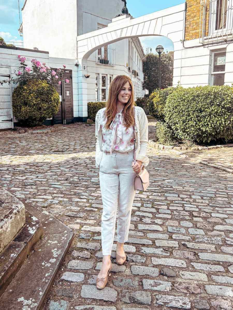 Chic layering for spring: cigarette trousers styled with a floral blouse, cardigan, and ballet flats