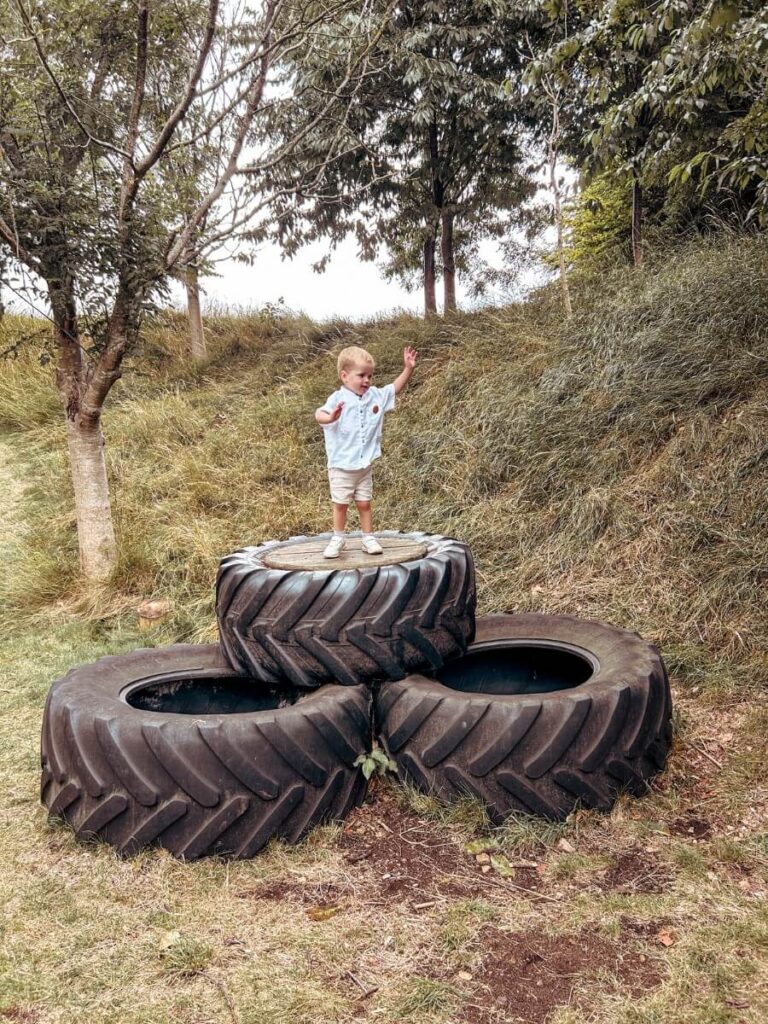 Climbing on tyres at the Beachwood Nature Trail in the Cotswolds with kids, a top Cotswolds itinerary activity