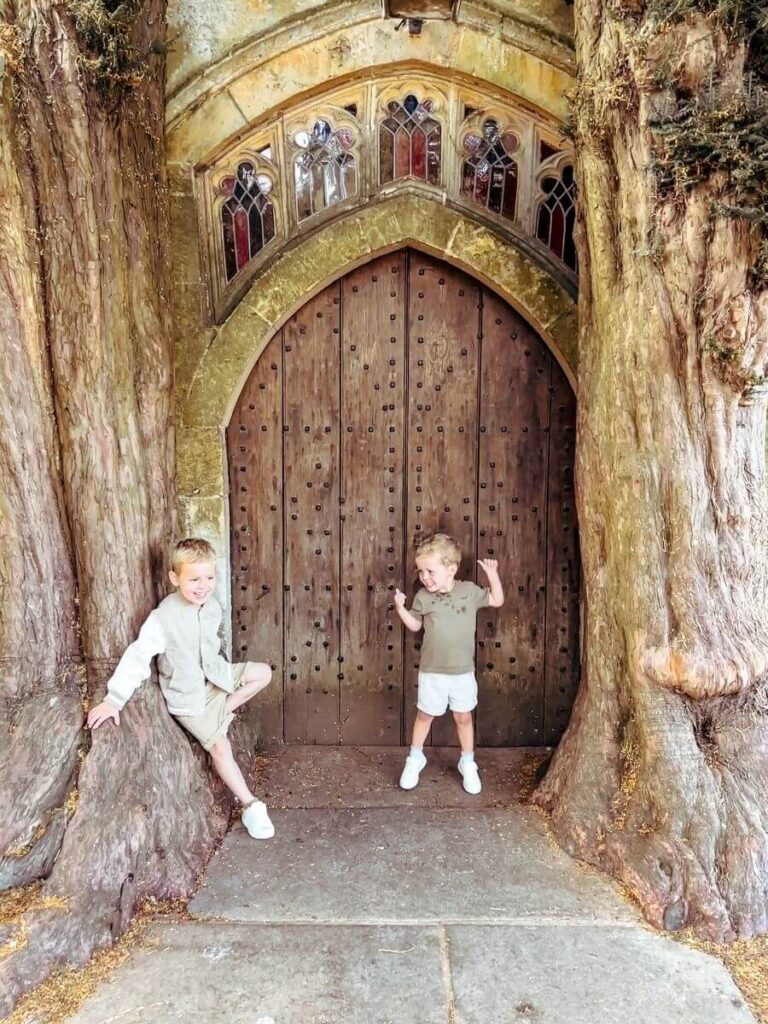 Kids standing by Tolkien’s Door at St Edwards Church, a unique place to visit in the Cotswolds