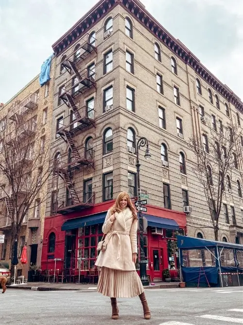 styling a pleated midi skirt for winter with a wool coat and structured bag. A chic, elegant look.