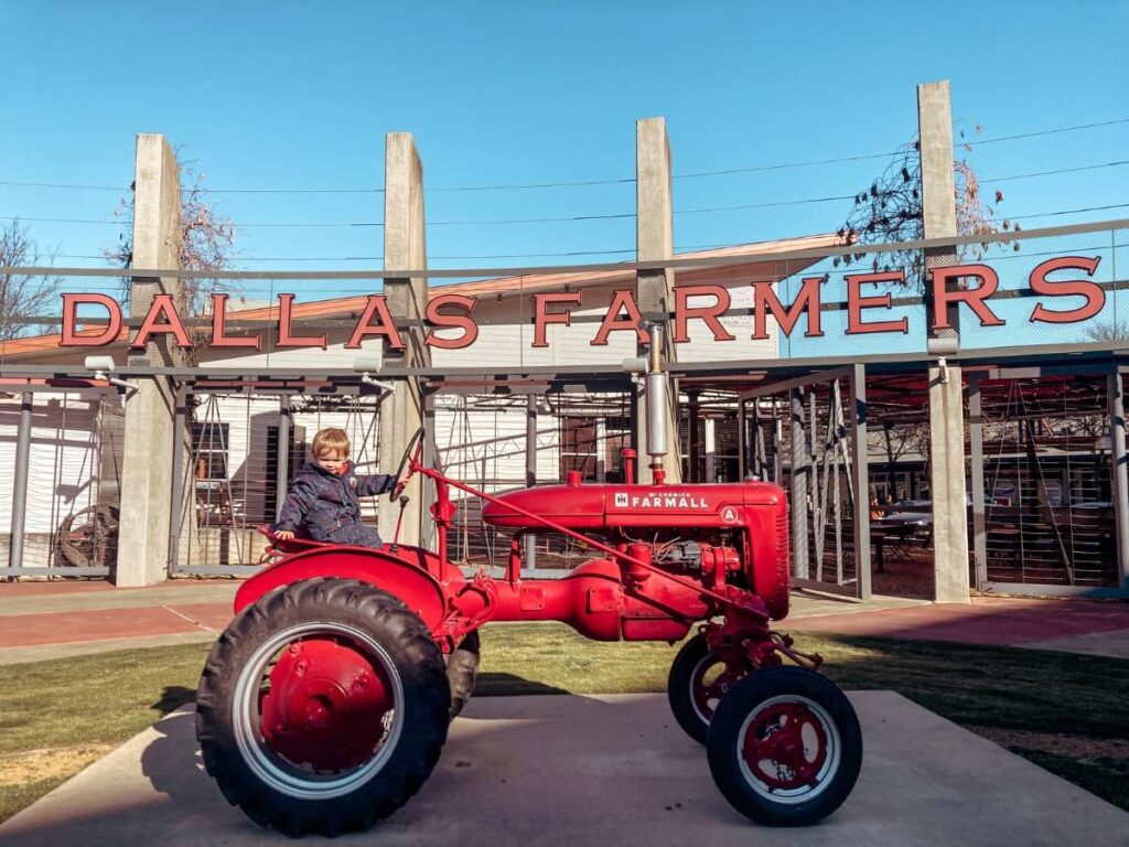 Riding the free red tractor outside the Farmers Market is one of the best things to do in Dallas with kids