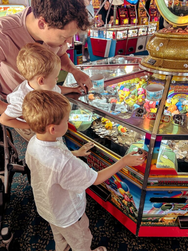 Playing on the 2p slot machines at Brighton Pier as a family.