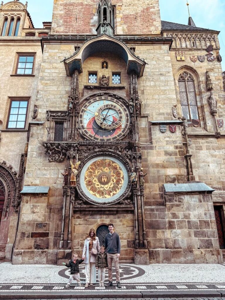 Family in front of the Astronomical Clock in Prague, a must top thing to see in Prague with kids.