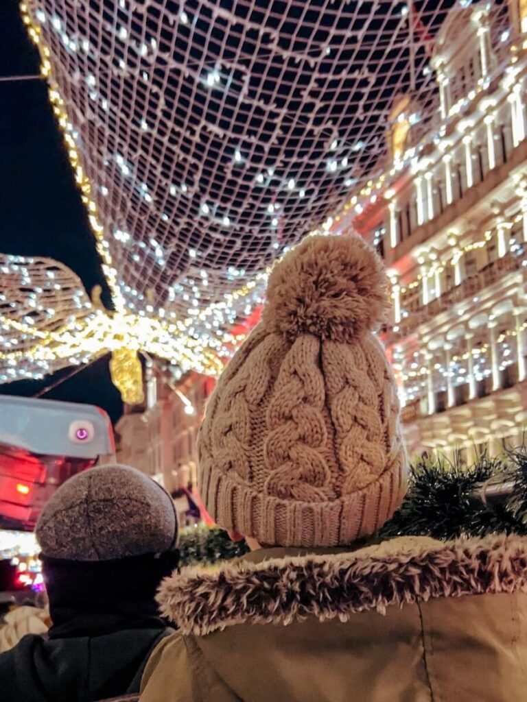 Child enjoying the magical views on a London Christmas lights bus tour.
