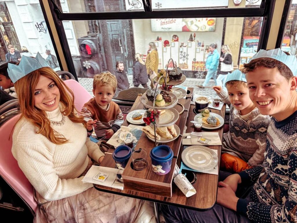 Family enjoying a Christmas afternoon tea on a London Bus
