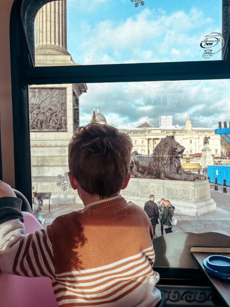 Child looking at the views of Trafalgar Square from the bus.