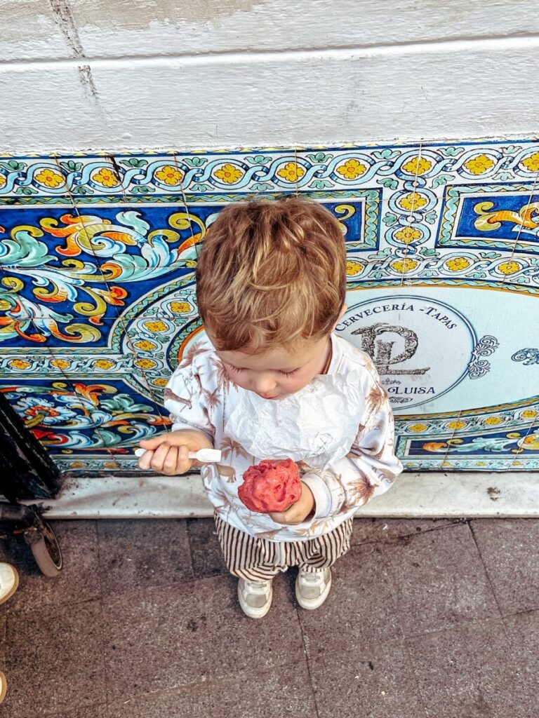 Child enjoying and ice cream form Gelateria MITO, a must do activity in Seville with kids.