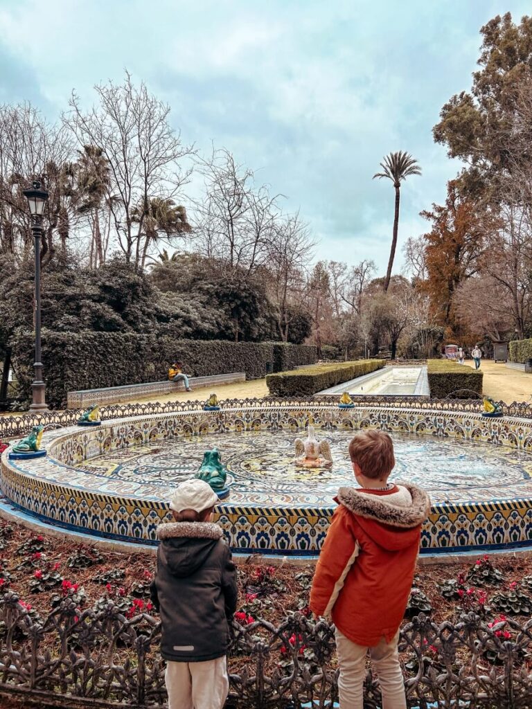 Children looking at a fountain in Parque de María Luisa. A must visit place in Seville with kids.