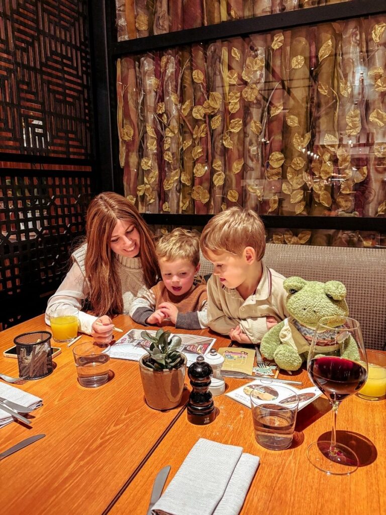 Enjoying a family dinner at Nine Elms Kitchen, with frog themed activity books for kids.