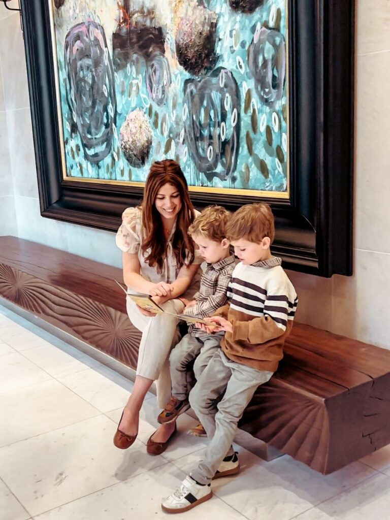 Mum in the City and her kids in the Lobby of Park Hyatt River Thames London, looking at the children's passport activity book.