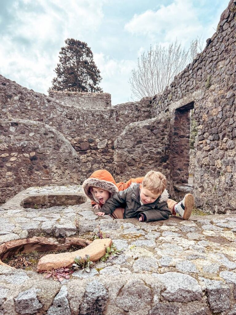 Children enjoying the ruins of Pompeii's Archaeological site during a family visit. 