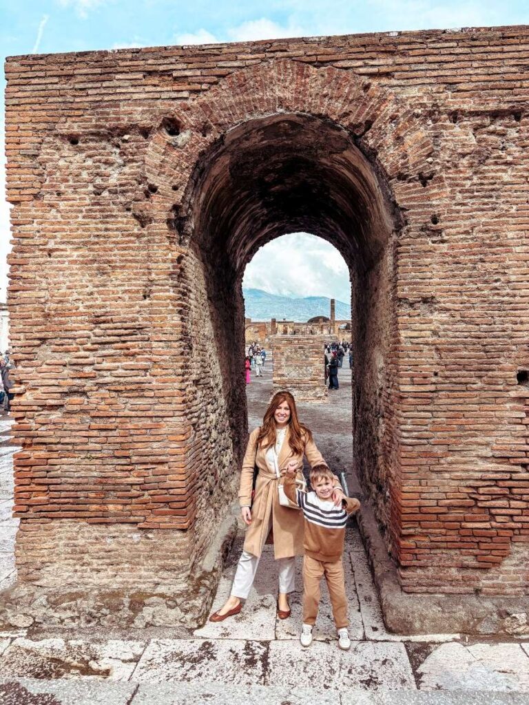 Mother and child exploring the vast Roman Forum at the Pompeii Archaeological site. 