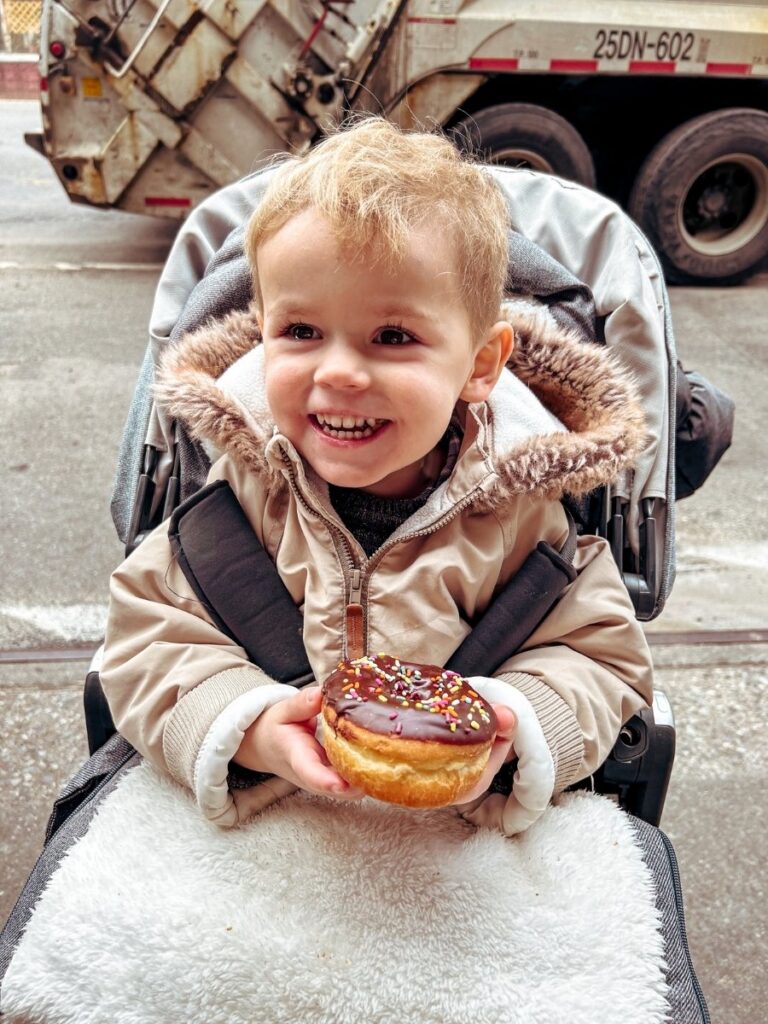 Toddler enjoying a Dunkin Donut treat after a lot of walking in NYC.
