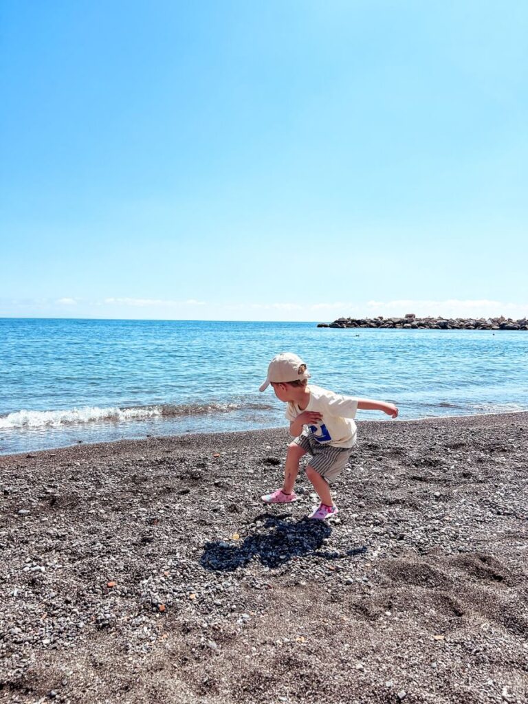 Child playing on Atrani Beach, just a short walk rom Amalfi and much quieter.