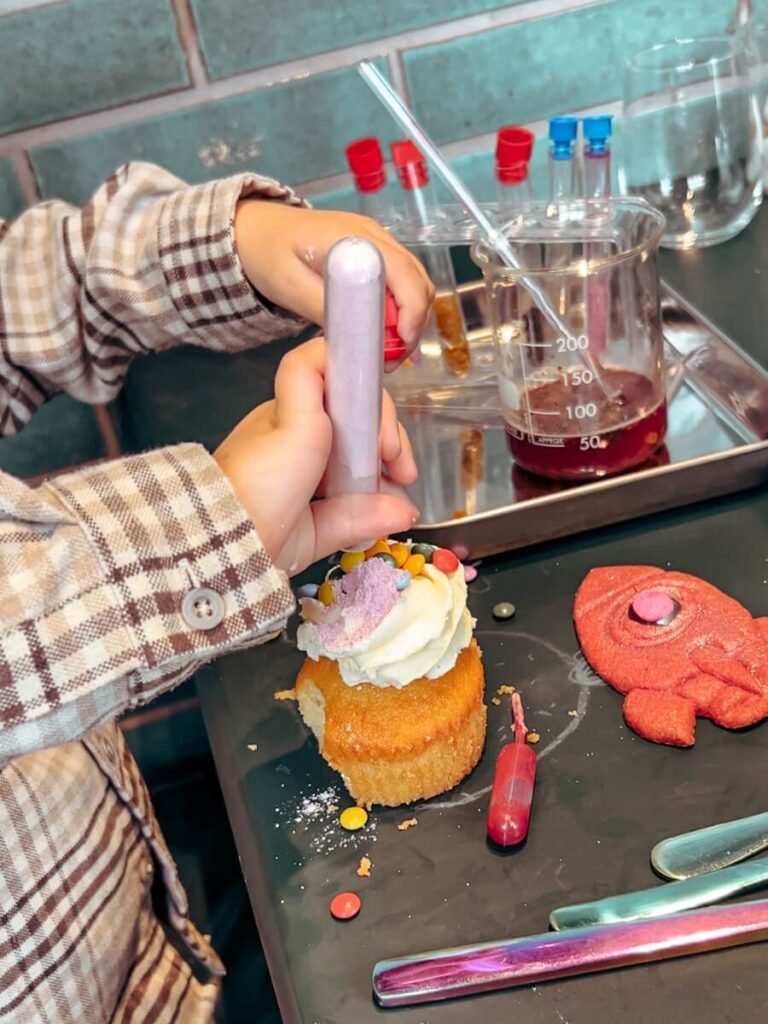 Child decorating cupcakes at the Science Museum Afternoon Tea in London.