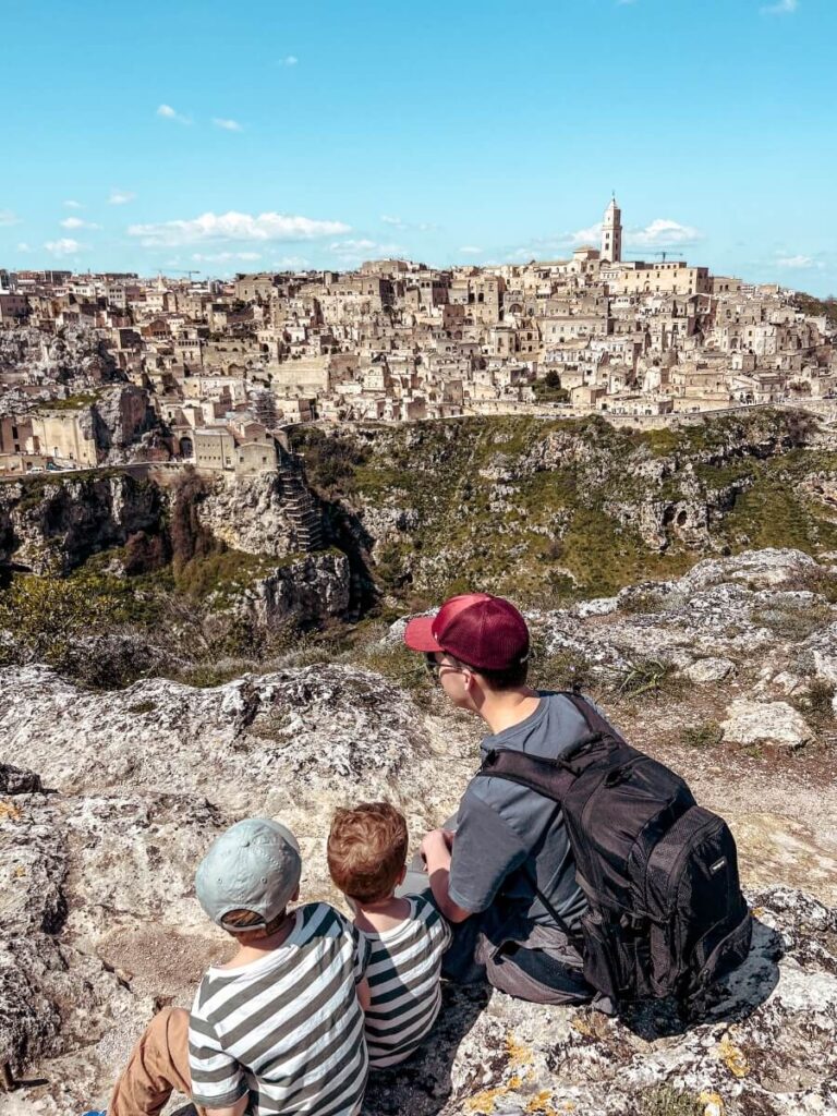 Family overlooking the view from the top of Belvedere Murgia Timone hike in Matera.