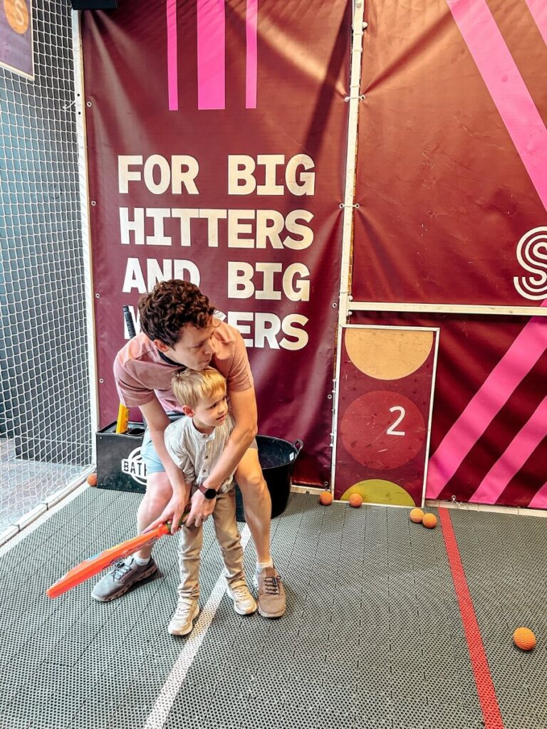 Batting at Sixes Cricket, a fun activity for a rainy day in London.